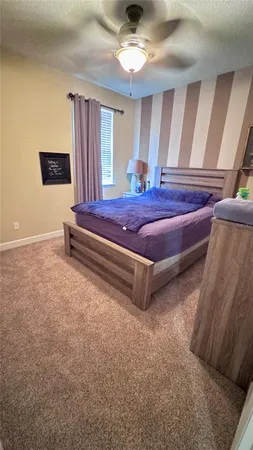 a bedroom with a bed and a ceiling fan