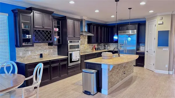 a kitchen with stainless steel appliances granite countertop a sink a stove and a refrigerator