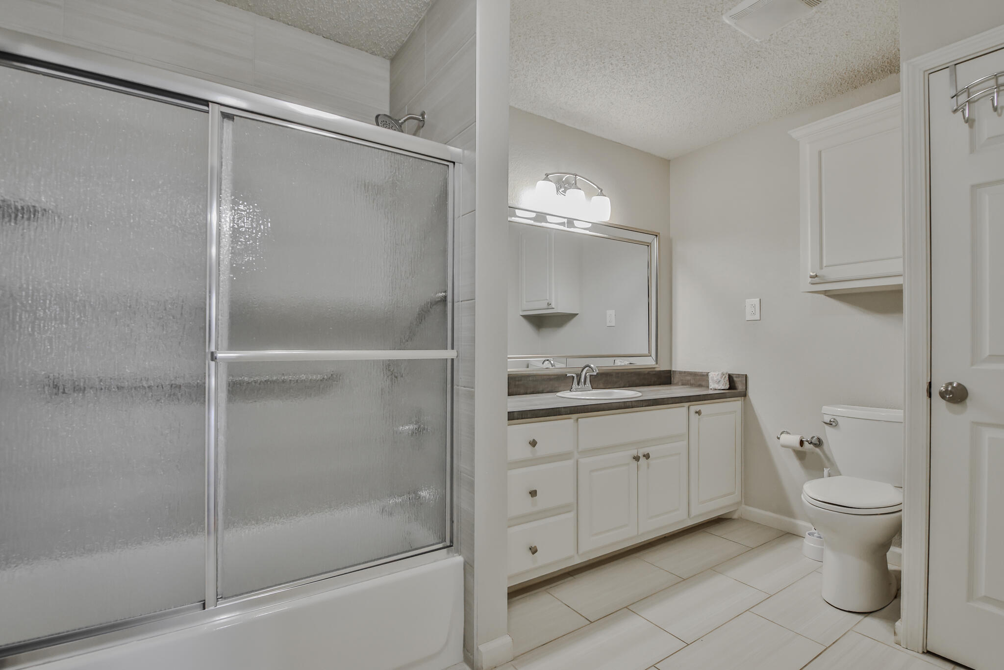 5437 45th Street Lubbock, TX 79414 - Photo 20 of 52 a bathroom with a granite countertop sink a toilet and shower