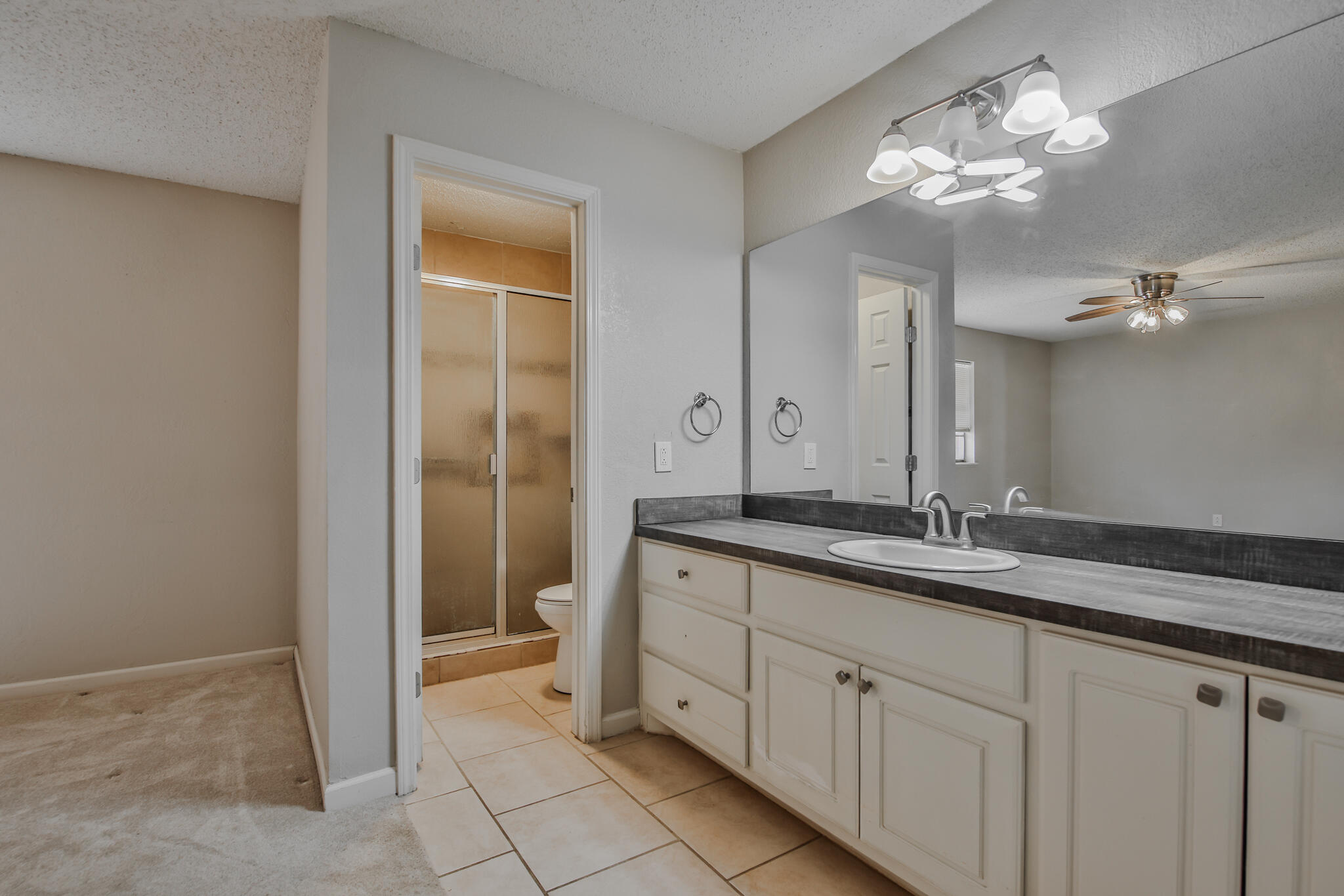 5437 45th Street Lubbock, TX 79414 - Photo 28 of 52 a spacious bathroom with a granite countertop sink a mirror and a vanity