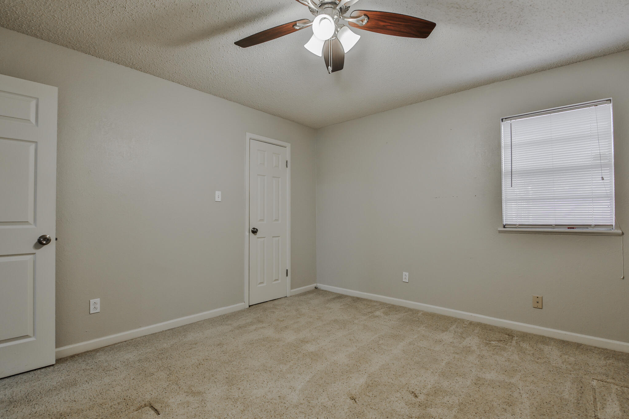 5437 45th Street Lubbock, TX 79414 - Photo 40 of 52 an empty room with a chandelier fan and windows