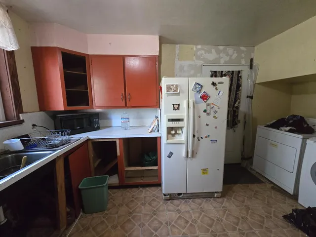 a kitchen with a refrigerator and a sink