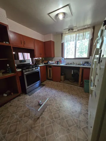 a large kitchen with stainless steel appliances granite countertop a stove sink and cabinets