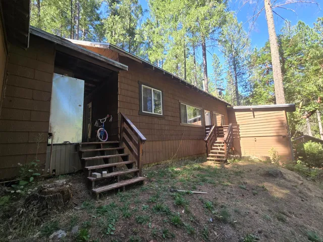 a view of a house with backyard and trees