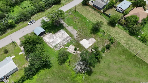 an aerial view of residential house with outdoor space and trees all around