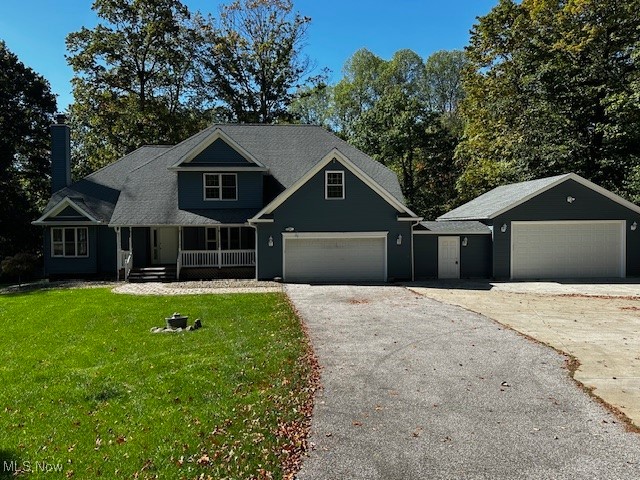 12470 Caves Road Chesterland, OH 44026 - Photo 1 of 24 Craftsman-style home featuring a garage, a porch, a front lawn, a chimney, and driveway