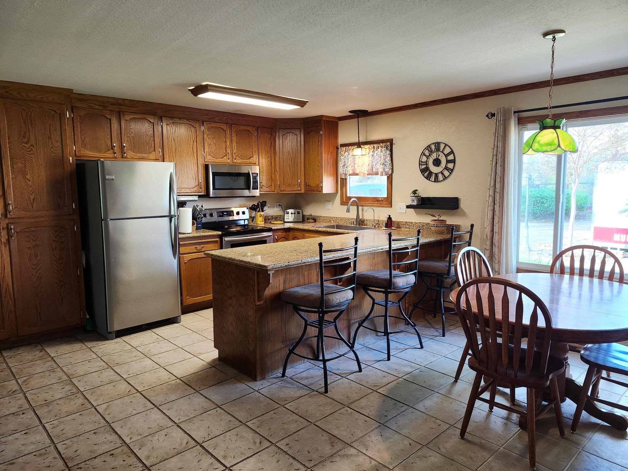 81 Yula Way Oakley, CA 94561 - Photo 29 of 44 a kitchen with stainless steel appliances granite countertop a stove a refrigerator a dining table and chairs