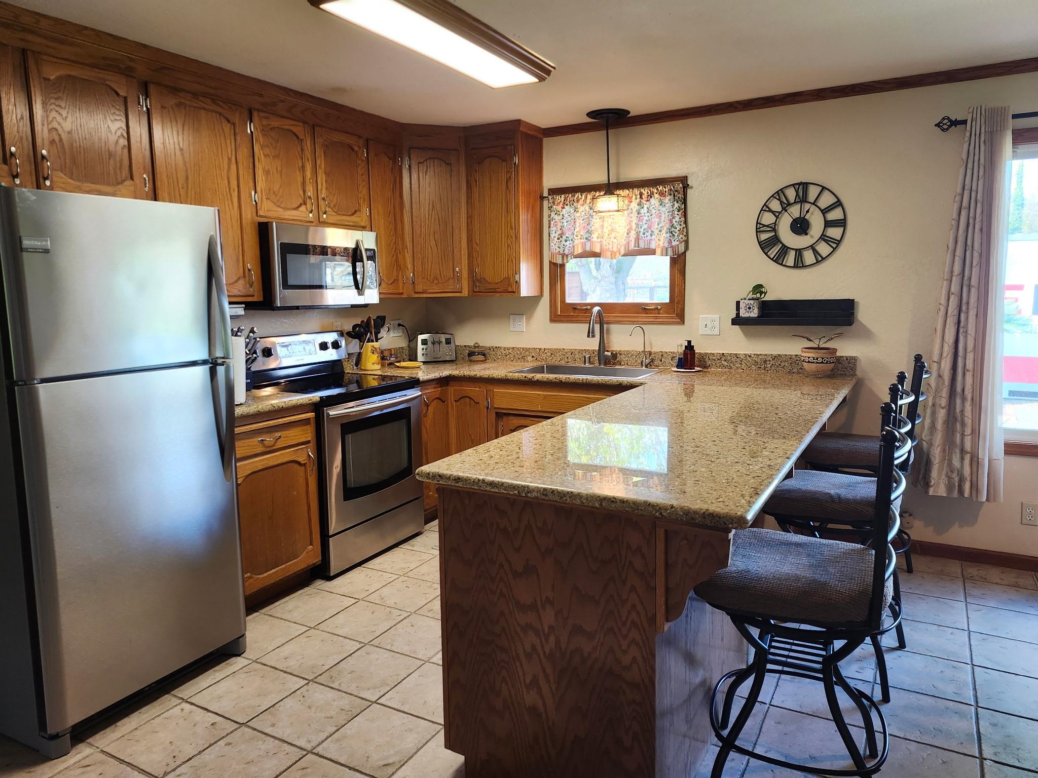 81 Yula Way Oakley, CA 94561 - Photo 30 of 44 a kitchen with granite countertop stainless steel appliances a refrigerator a stove a sink dishwasher a dining table and chairs with wooden floor
