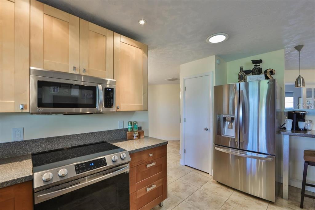 1820 El Rancho Drive Sun City Center, FL 33573 - Photo 36 of 70 a kitchen with stainless steel appliances a refrigerator a stove a microwave and cabinets