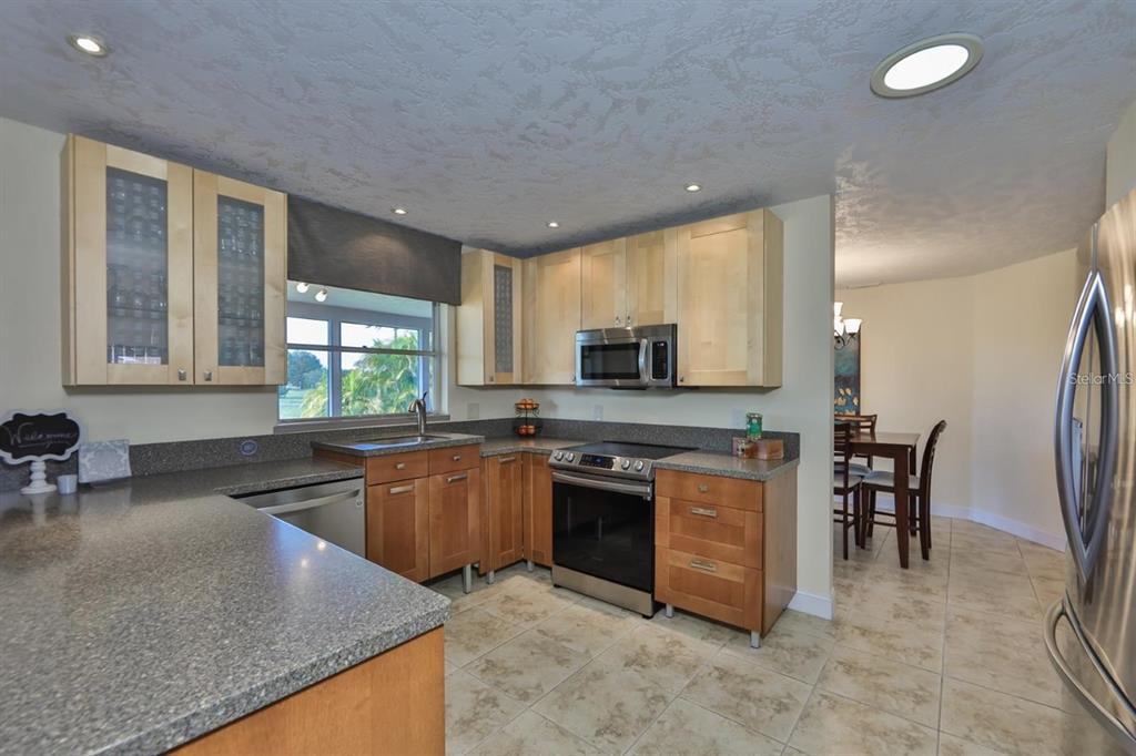 1820 El Rancho Drive Sun City Center, FL 33573 - Photo 39 of 70 a kitchen with stainless steel appliances granite countertop a stove a sink a refrigerator and a microwave