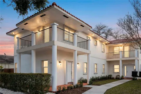 a view of a white house with a yard