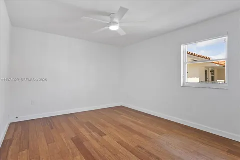 a view of a room with wooden floor and a ceiling fan