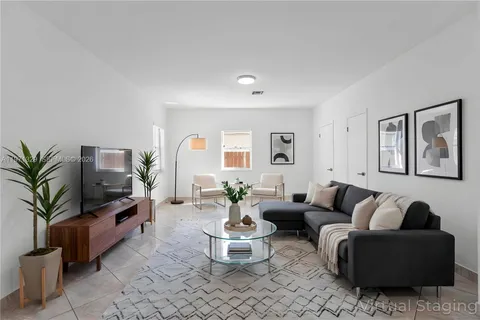 a living room with furniture and a potted plant