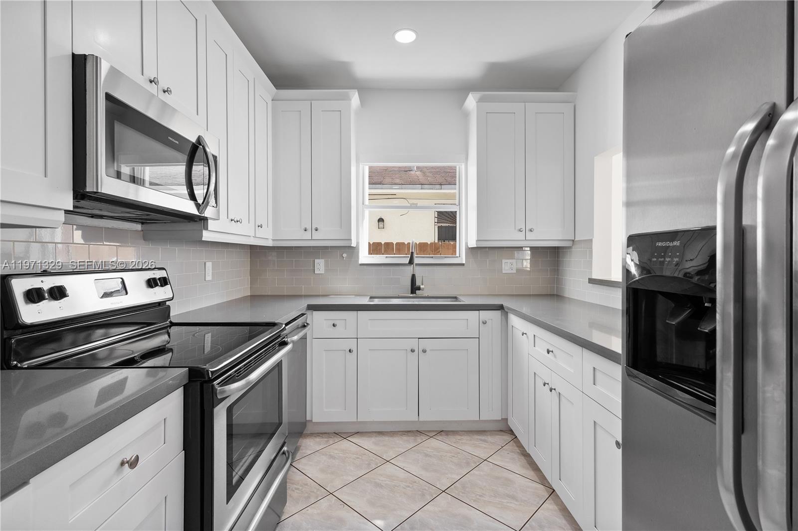 2870 Southwest 21st Street Miami, FL 33145 - Photo 10 of 34 a kitchen with stainless steel appliances granite countertop a stove microwave and cabinets