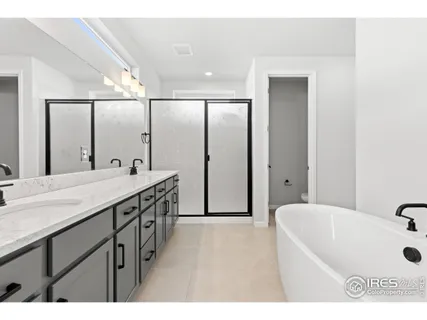 a bathroom with a double vanity sink a mirror and a bathtub