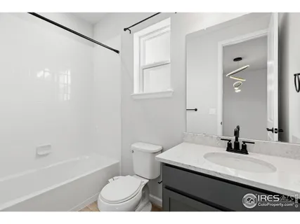 a bathroom with a sink a toilet a mirror and shower