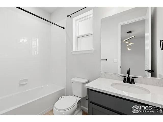 a bathroom with a sink a toilet a mirror and shower