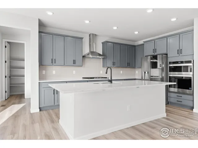 a kitchen with kitchen island a stove a sink and a refrigerator