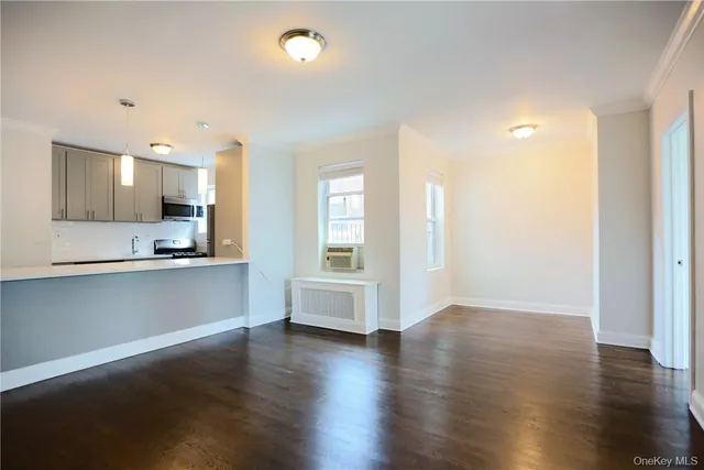 an open kitchen with white cabinets and wooden floor