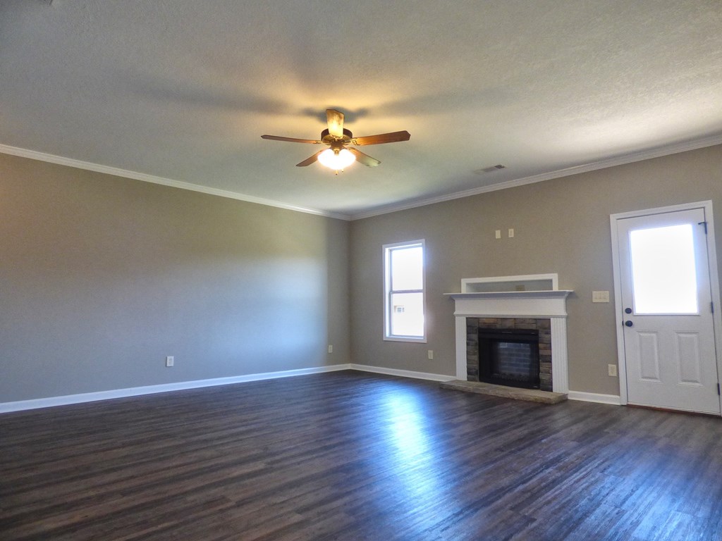 301 Owens Road Fort Mitchell, AL 36856 - Photo 3 of 17 an empty room with windows fireplace and a wooden floor