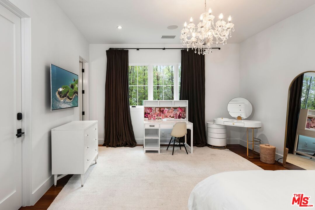 24848 Long Valley Road Hidden Hills, CA 91302 - Photo 24 of 38 a bed room with a bed and a chandelier