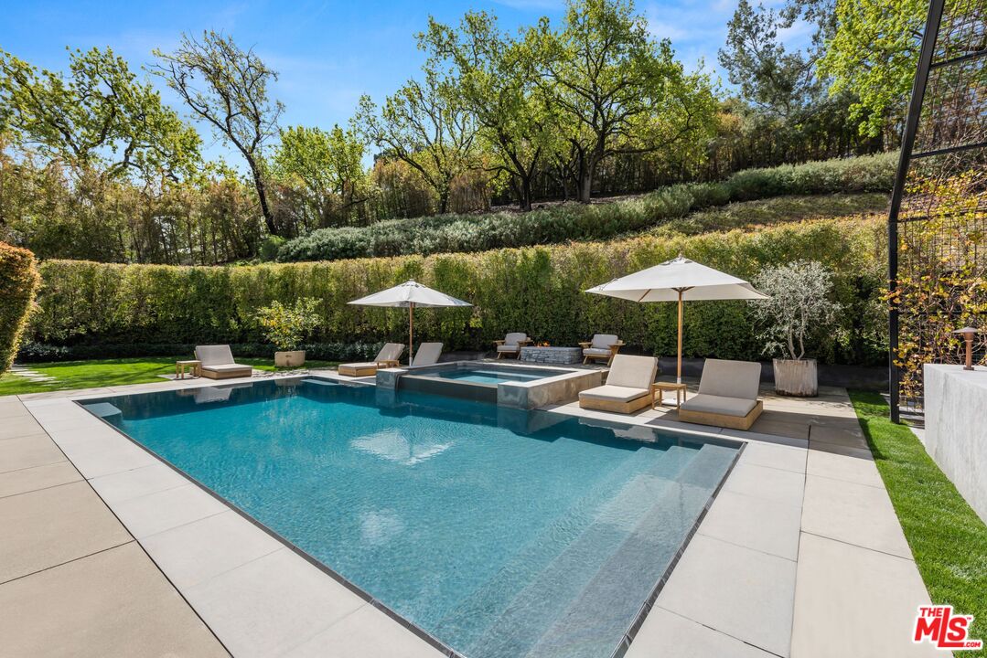 24848 Long Valley Road Hidden Hills, CA 91302 - Photo 31 of 38 a view of swimming pool with lounge chair under an umbrella