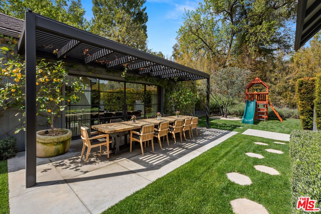 24848 Long Valley Road Hidden Hills, CA 91302 - Photo 32 of 38 a view of a patio with table and chairs under an umbrella with a barbeque