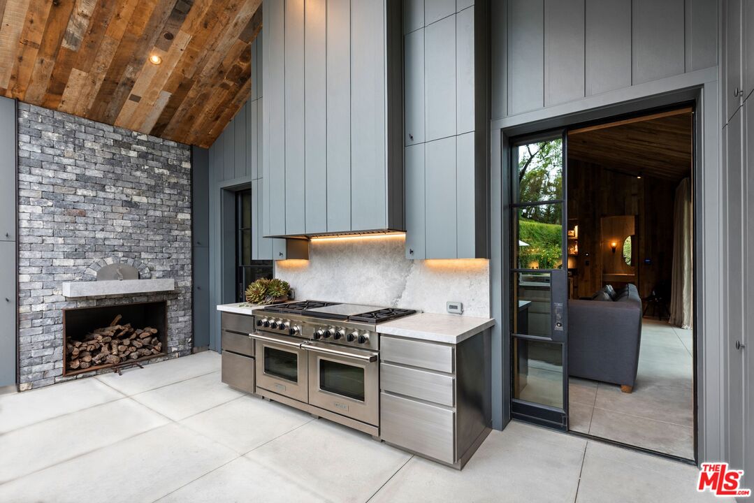 24848 Long Valley Road Hidden Hills, CA 91302 - Photo 33 of 38 a kitchen with a stove and a fireplace