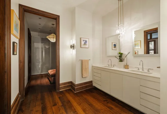 a spacious bathroom with a double vanity sink a mirror and a shower