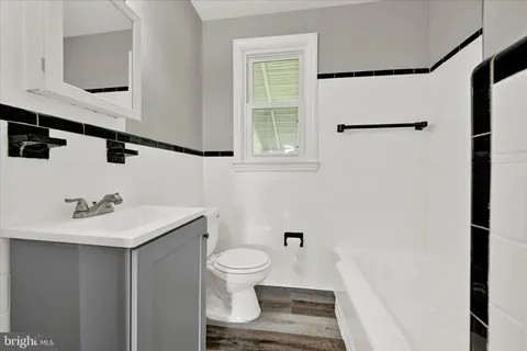 a bathroom with a sink toilet and mirror