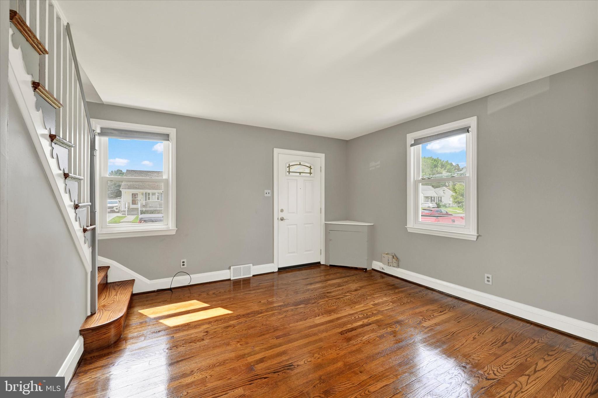 6820 Bessemer Avenue Baltimore, MD 21222 - Photo 5 of 17 a view of an empty room with wooden floor and a window