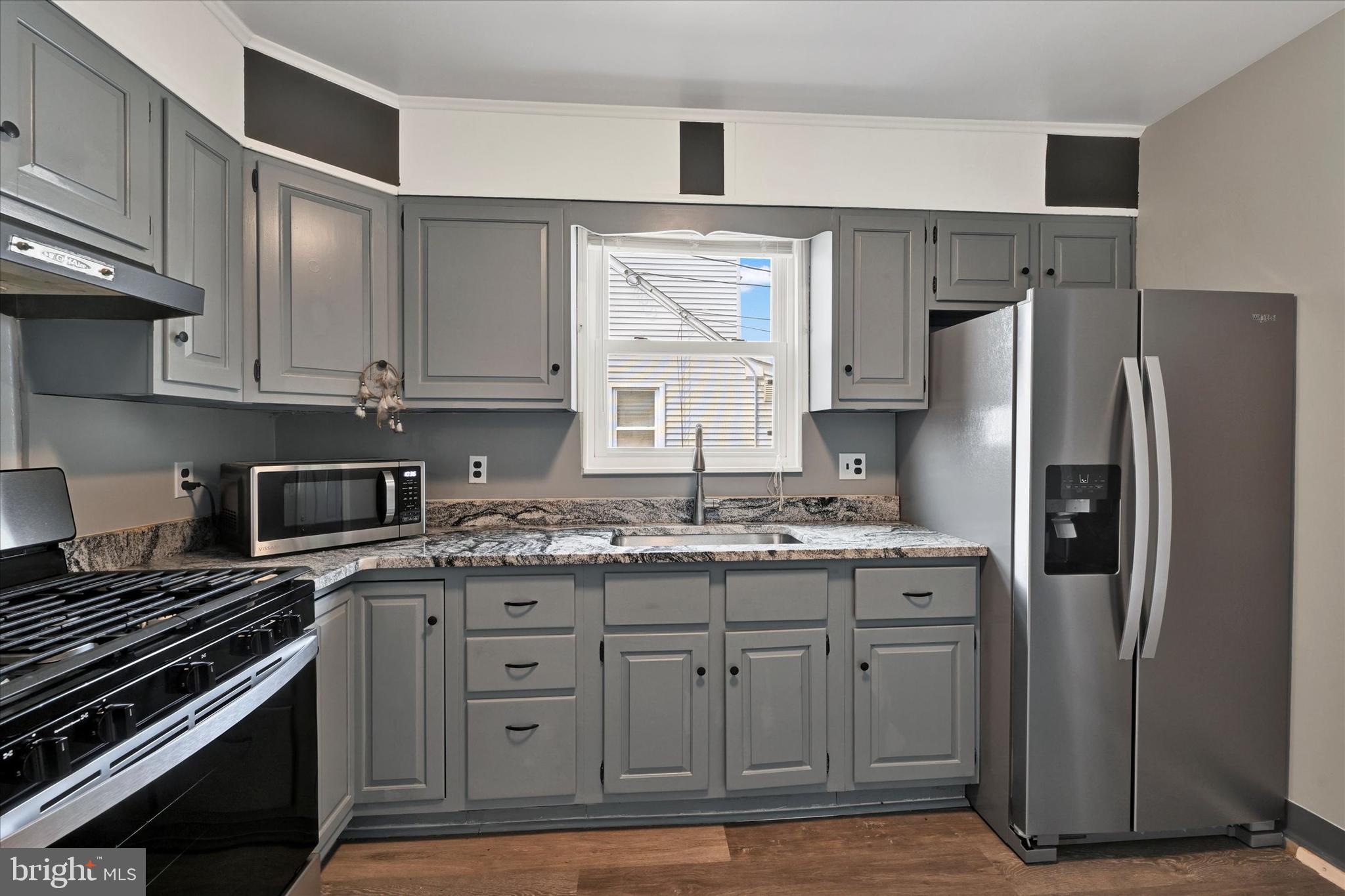 6820 Bessemer Avenue Baltimore, MD 21222 - Photo 8 of 17 a kitchen with a stove and a refrigerator