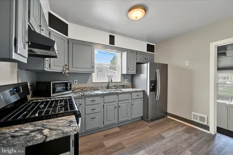 a kitchen with stainless steel appliances granite countertop a stove a refrigerator and a microwave