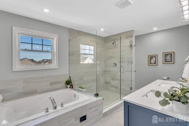 a bathroom with a tub sink and mirror