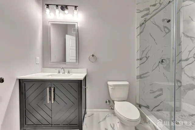 a bathroom with a toilet sink vanity and mirror