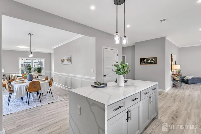 a view of a dining room and livingroom with furniture wooden floor a chandelier
