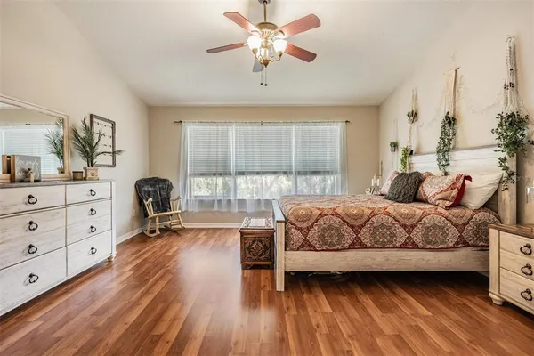 a bedroom with a bed and a large window with the outer view