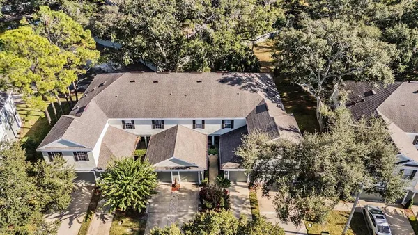 an aerial view of a house with a yard and large trees