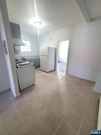 a kitchen with granite countertop a refrigerator and a stove