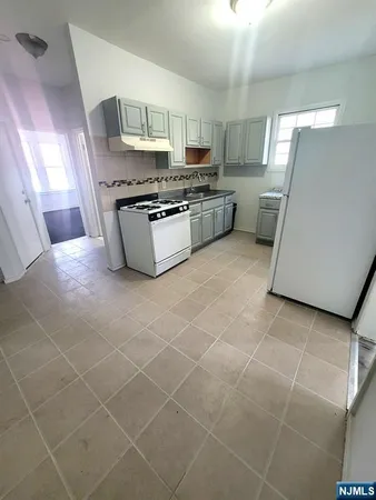 a kitchen with granite countertop a stove a sink and a refrigerator