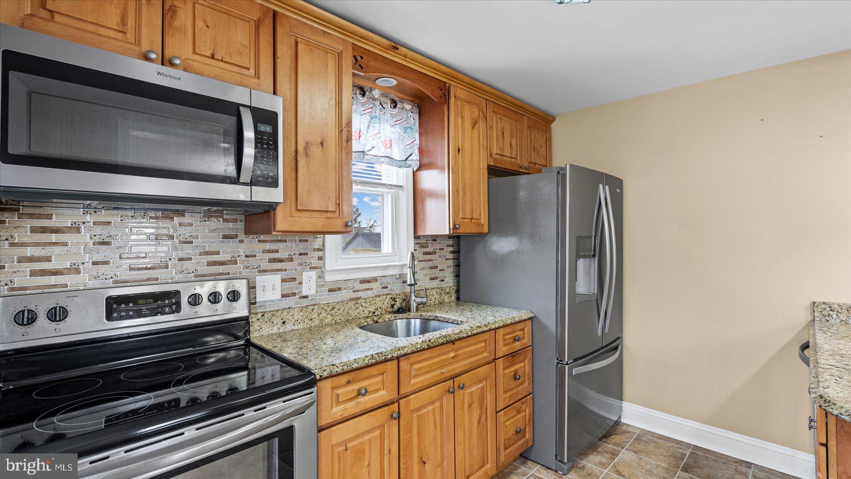 1821 Weyburn Road Baltimore, MD 21237 - Photo 11 of 45 a kitchen with stainless steel appliances granite countertop a refrigerator stove and microwave