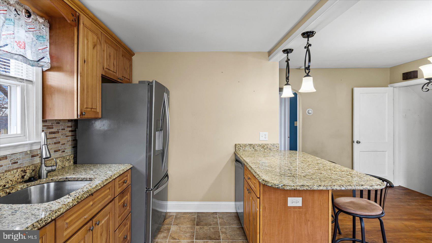 1821 Weyburn Road Baltimore, MD 21237 - Photo 13 of 45 a kitchen with granite countertop a sink and a refrigerator