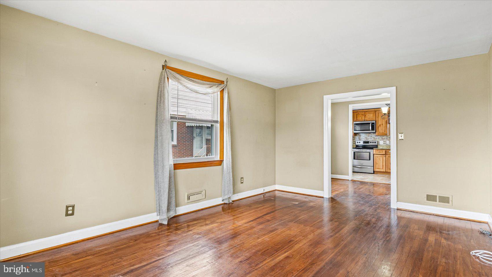 1821 Weyburn Road Baltimore, MD 21237 - Photo 6 of 45 a view of an empty room with wooden floor and a window