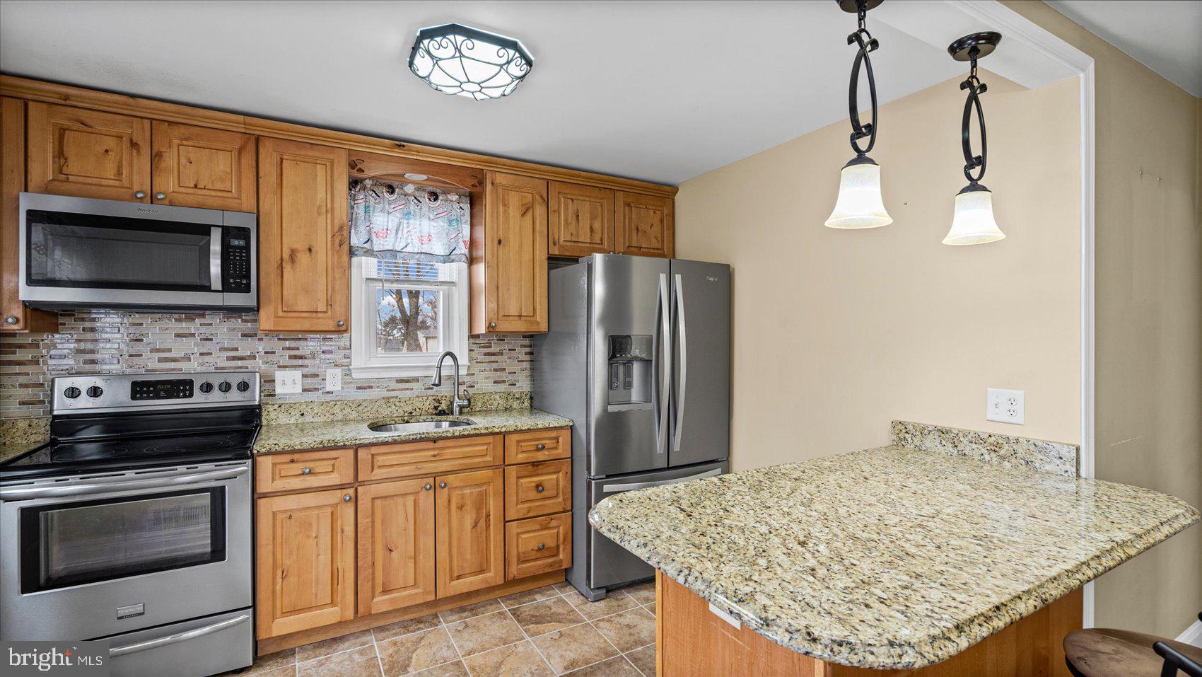 1821 Weyburn Road Baltimore, MD 21237 - Photo 10 of 45 a kitchen with stainless steel appliances granite countertop a stove refrigerator sink and microwave