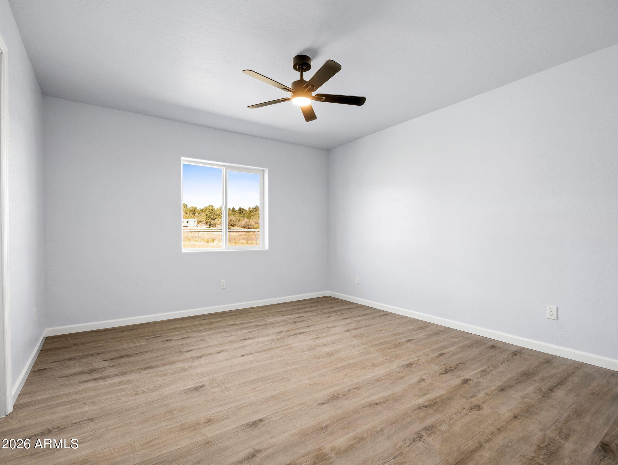 18278 Frontier Road Peeples Valley, AZ 86332 - Photo 20 of 31 wooden floor in an empty room with a window