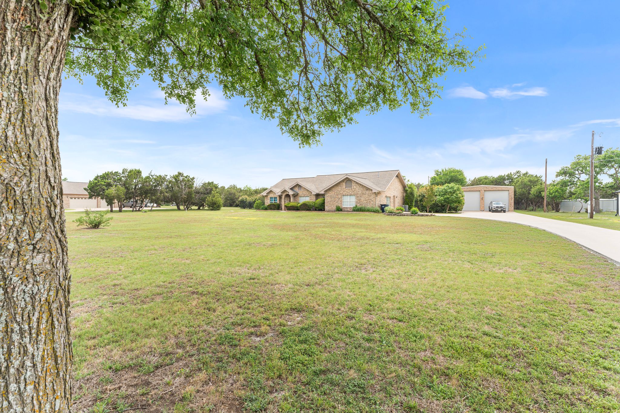 221 Breakaway Road Cedar Park, TX 78613 - Photo 3 of 39 View of front facade with a detached garage, a front lawn, and concrete driveway
