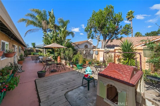 a view of a patio with table and chairs potted plants and palm tree