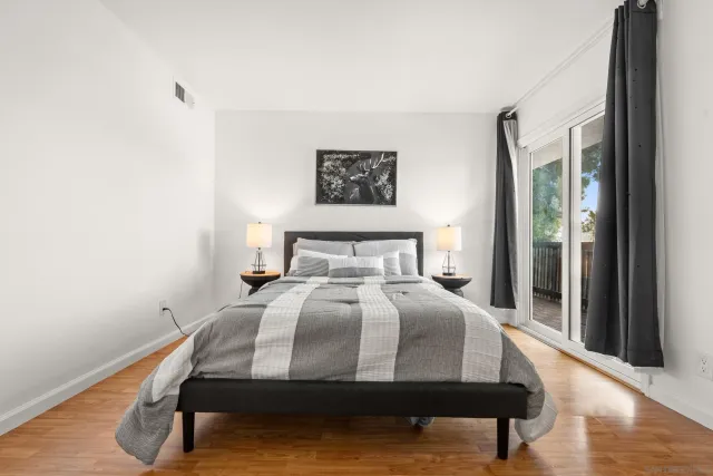 a bedroom with a bed and wooden floor
