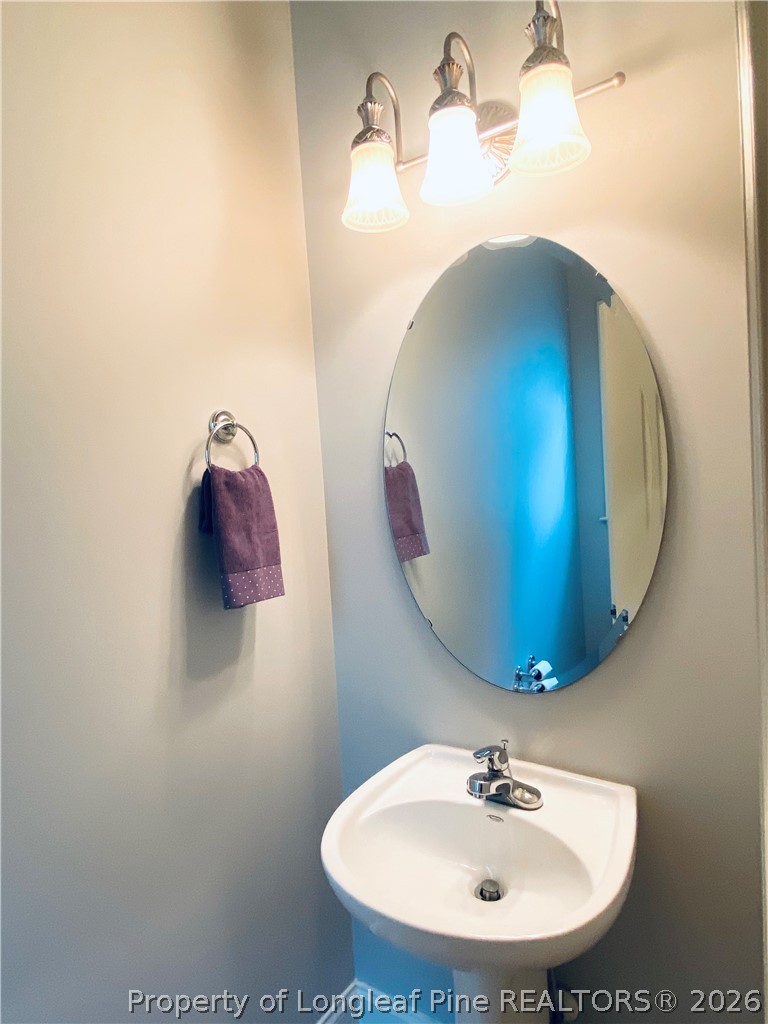 175 Pine Hawk Drive Spring Lake, NC 28390 - Photo 27 of 43 a bathroom with a sink and a mirror