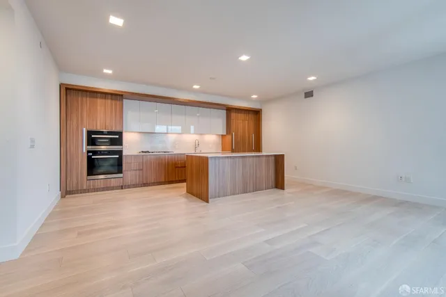 a kitchen with granite countertop white cabinets and stainless steel appliances